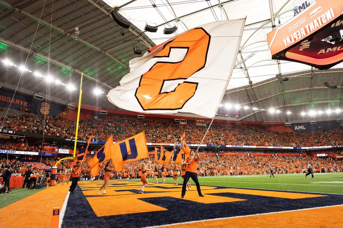 Student waiving a Syracuse University flag in the JMA Wireless Dome.